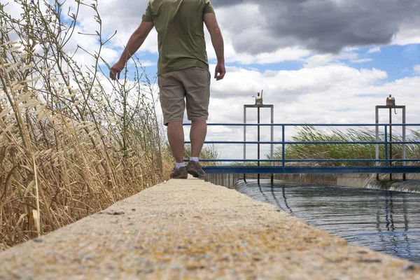 巨大な灌漑運河沿いを歩いてキーパー — ストック写真