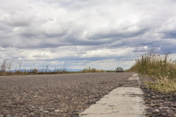 Coche solitario viajando por los verdes prados — Foto de Stock