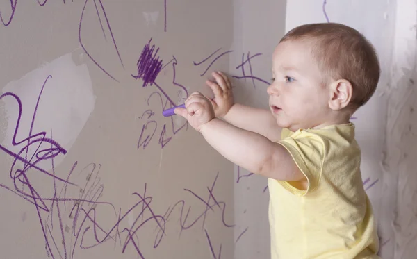 Малыш рисует на стене — стоковое фото