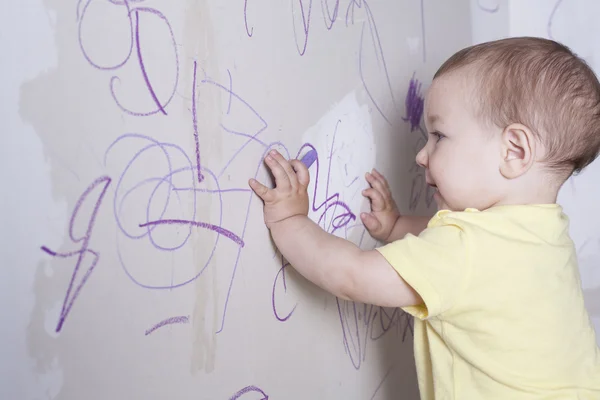 Bébé garçon dessin avec crayon de cire sur le mur de placoplâtre — Photo