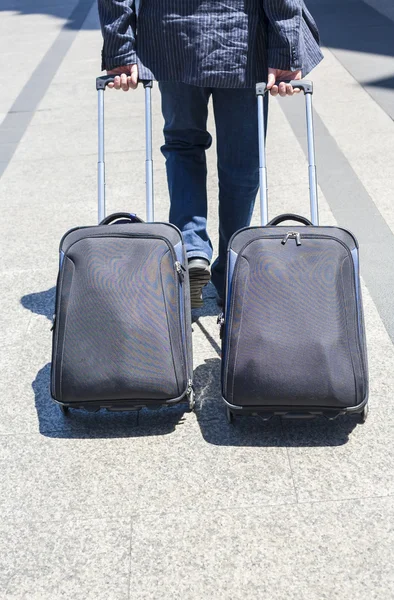 Jovem caminhando com duas malas — Fotografia de Stock