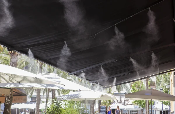 Tendalino irrigatori spruzzi d'acqua al bar terrazza — Foto Stock