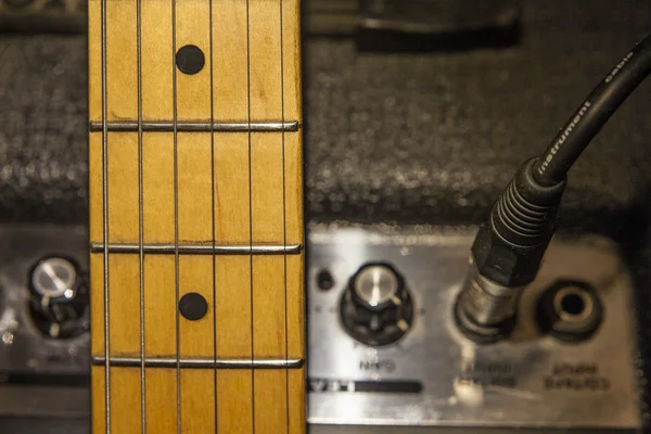 Gitarr halsen över förstärkare enhet och ljudkabel — Stockfoto