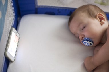 cep telefonundan bir ninni şarkıları ile uyuyan bebek