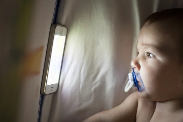 Bebé viendo una canción de cuna de dibujos animados con teléfono móvil en la cuna — Foto de Stock