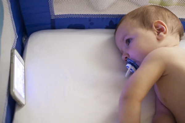 Figyeli a lullaby Rajzfilmek a mobil telefon a kiságy a baba — Stock Fotó