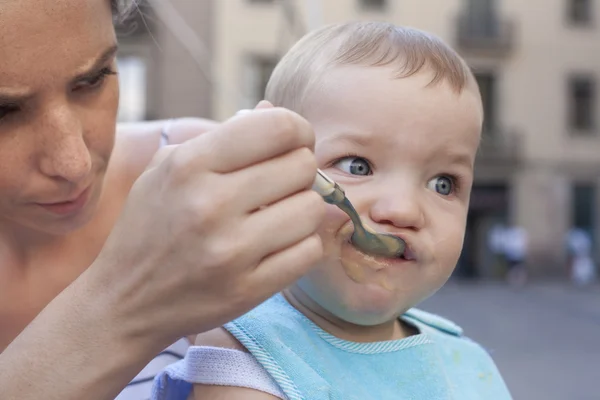 Moeder haar babyjongen buitenshuis voeding — Stockfoto