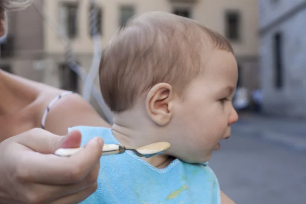 Moeder probeert te voeden haar babyjongen — Stockfoto