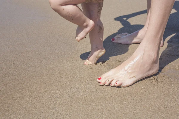 Anya és a baba lábát séta a homokos strand — Stock Fotó