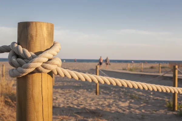 Paletti con corda sulla spiaggia al tramonto — Foto Stock