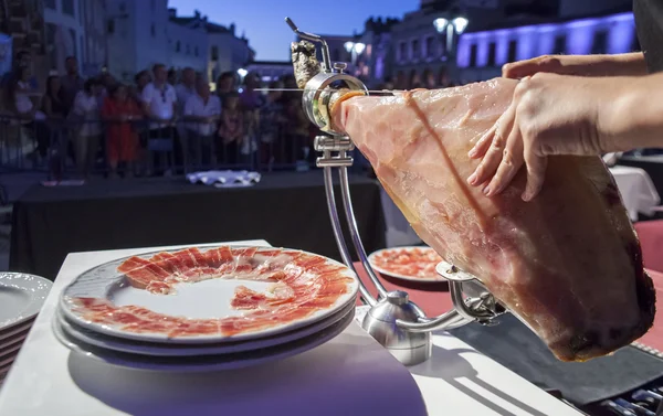 Master slicer cutting iberian cured ham at public exhibition — Stock Photo, Image