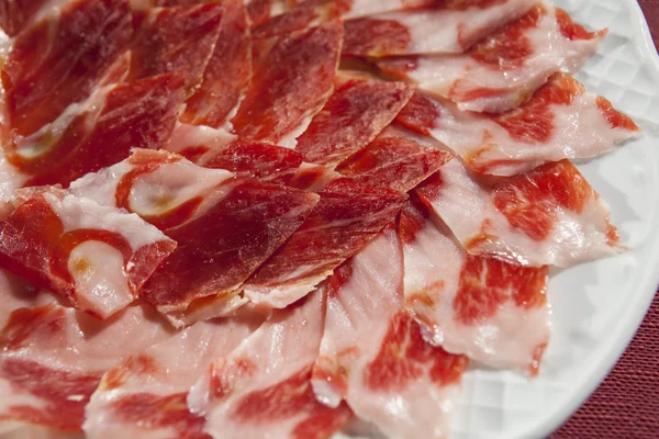 Decoratieve rangschikking van Iberische gerookte ham op plaat — Stockfoto