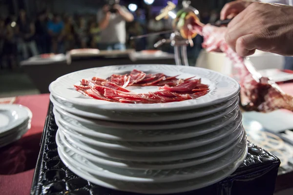 Master slicer cutting iberian cured ham at public exhibition — Stock Photo, Image