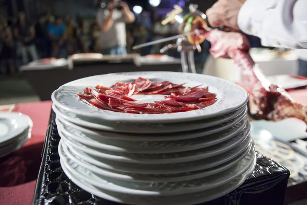 Master slicer cutting iberian cured ham at public exhibition — Stock Photo, Image