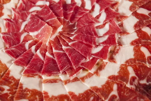 Circular decorative arrangement of iberian cured ham on plate — Stock Photo, Image