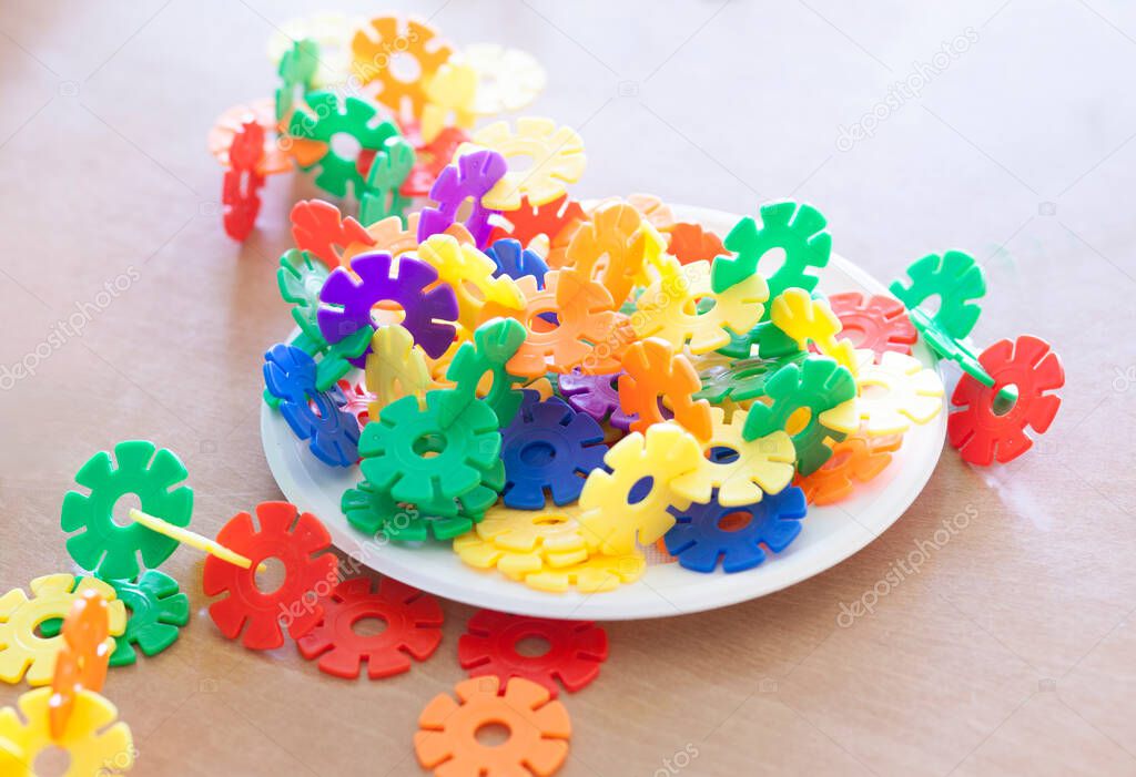 Plastic flakes blocks on plate. Instructive toy that promotes spatial hhinking and fine motor skills