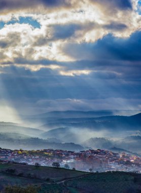 İspanya 'nın Caceres şehrinde sisli bir gündoğumu sırasında Guadalupe köyünün göz kamaştırıcı manzarası