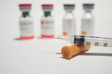 Ortaya çıkarılmış şırınga ve aşı ampulleri veya cam şişeler. Seçici odaklanma. Beyazlar üzerinde izole edilmiş