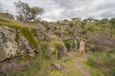 Çocuklar Muelas Köprüsü 'nü geçip granitik mağaralara yakın bir yere gidiyorlar. Cornalvo Doğal Parkı, Extremadura, İspanya