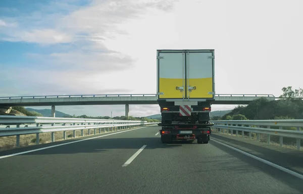 Heavy tow truck carrying semi-trailer truck on freeway. Truck Height Restrictions and Bridge Clearance concept