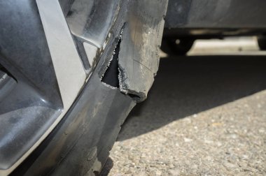 Patlamadan sonra yolda lastiği patlamış bir araba tekerleği. Yakın çekim.