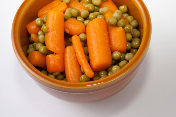 Kom gekookte wortelen en groene erwten — Stockfoto