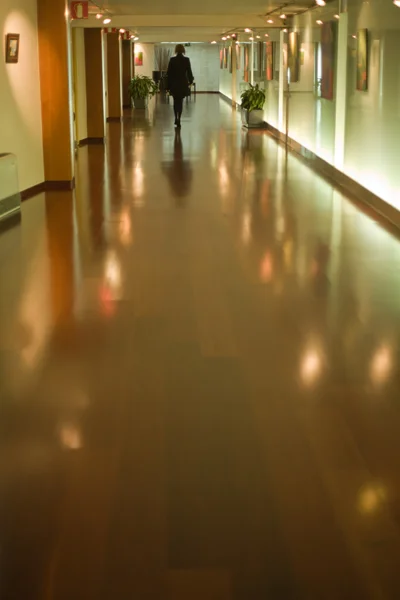 Kobieta przechodziła przez korytarz hotel — Zdjęcie stockowe