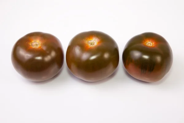 Três tomates kumato — Fotografia de Stock