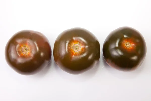 Três tomates kumato — Fotografia de Stock