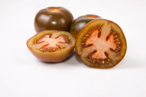 Tomates inteiros e fatiados de kumato — Fotografia de Stock