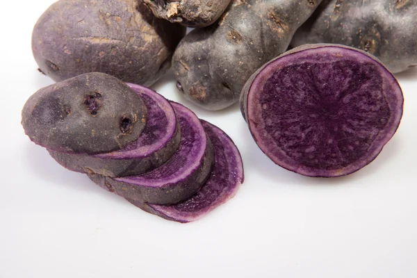 Sliced and whole Vitelotte potatoes — Stock Photo, Image