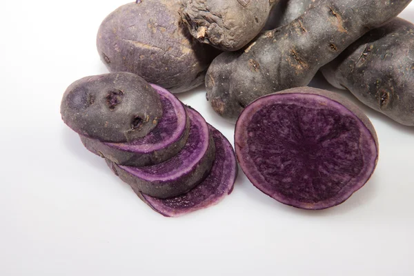 Sliced and whole Vitelotte potatoes — Stock Photo, Image
