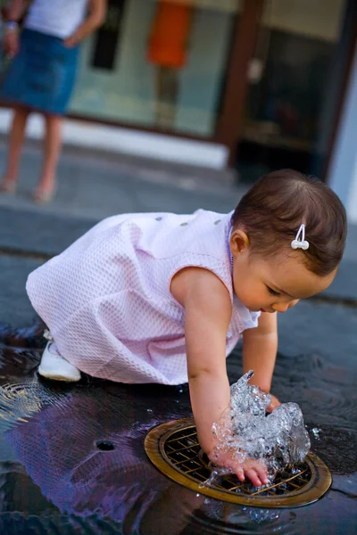 Baby spielt mit Springbrunnen — Stockfoto