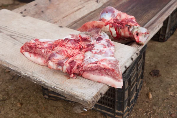Trozos de cerdo sobre bebedero de madera — Foto de Stock