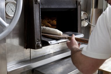 Çiğ ekmek fırın içine koyarak Baker