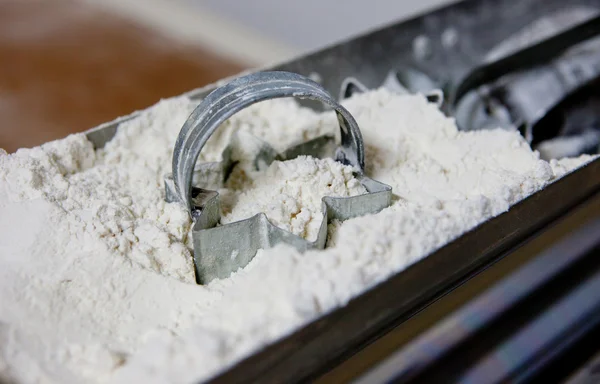 Cookie cutters in flour — Stock Photo, Image