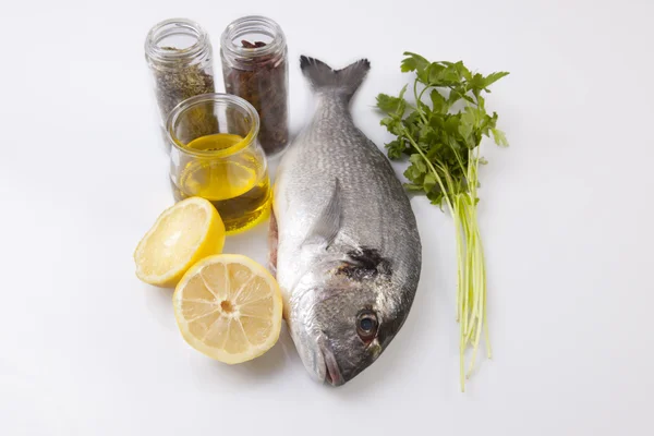 Raw sea bream fish with some ingredients — Stock Photo, Image