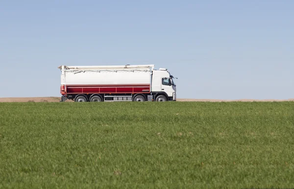 Op een groene landbouwgebied passerende vrachtwagen — Stockfoto