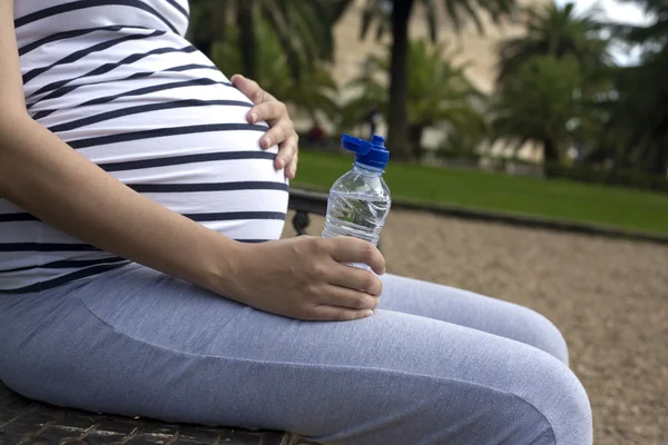 Беременная женщина пьет воду — стоковое фото