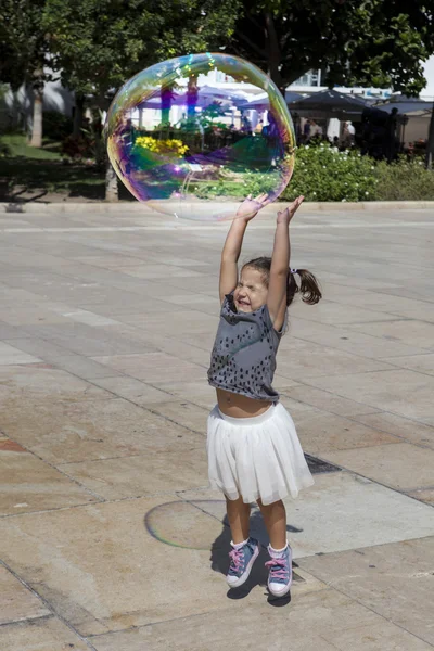 Spelen in de stad met een enorme zeepbel — Stockfoto