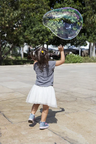 Spelen in de stad met een enorme zeepbel — Stockfoto