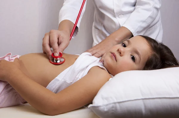Pediatra badania na łóżku — Zdjęcie stockowe