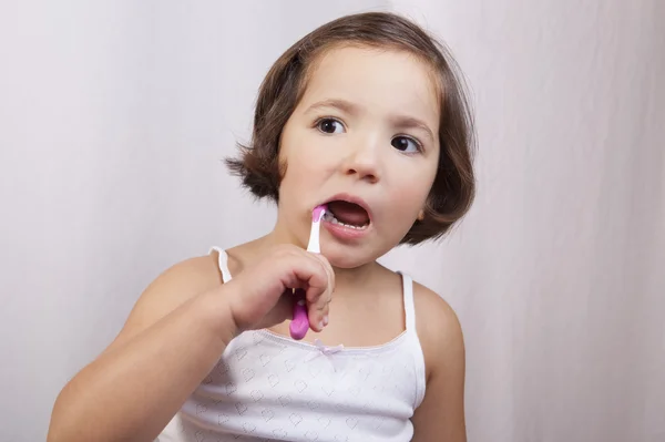 Mała dziewczynka oko brązowe szczotkowanie zębów — Zdjęcie stockowe