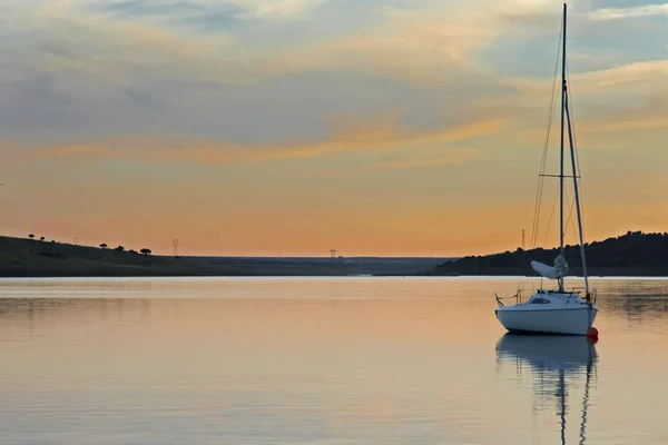 Sonnenuntergang über dem Alange Reservoir mit verankertem Segelboot, Spanien — Stockfoto