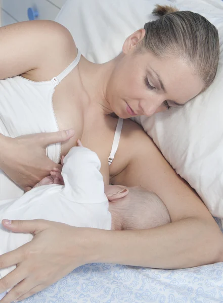 Ung mor ammer barnet sitt på soverommet sitt – stockfoto