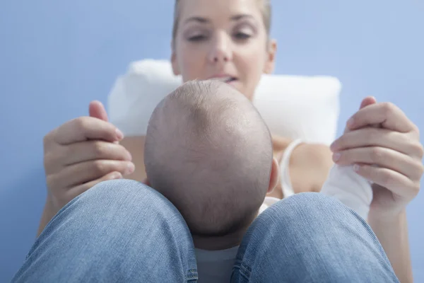 Jovem mãe brincando com seu bebê depois de alimentar o peito — Fotografia de Stock