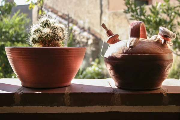 Brocca di terracotta e vaso di fiori di argilla contro la luce . — Foto Stock