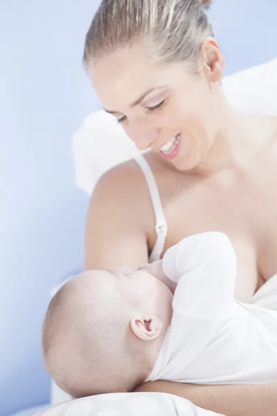 Joven madre jugando con su bebé después de la alimentación de mama — Foto de Stock