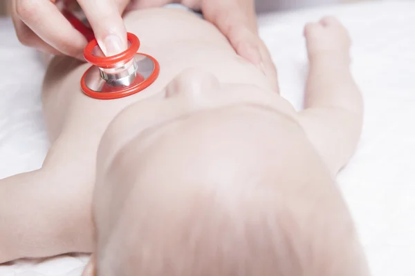 Barnläkare undersöker tre månader baby pojke med hjälp av ett stetoskop — Stockfoto