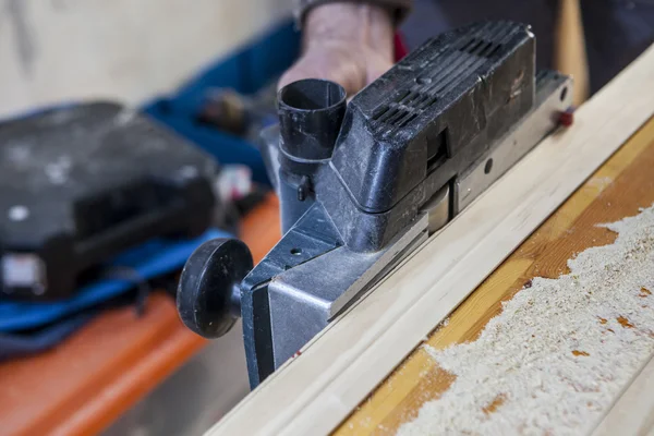 Carpenter using electric plane — Stock Photo, Image